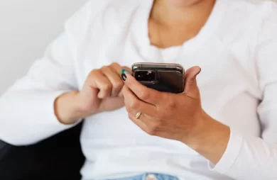 Mujer usando el móvil para navegar por redes sociales, representando la variedad de audiencias digitales en 2026.