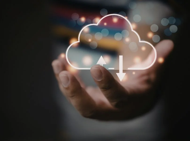 Mano sosteniendo un icono de nube con flechas de subida y bajada, representando un backup WordPress en la nube.