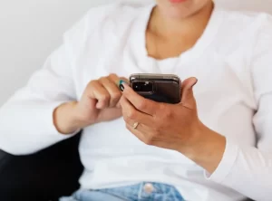Mujer usando el móvil para navegar por redes sociales, representando la variedad de audiencias digitales en 2026.